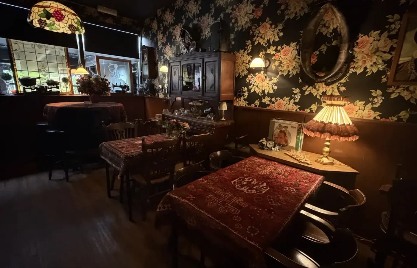 De stamtafel met Perzisch kleed en bloemenbehang