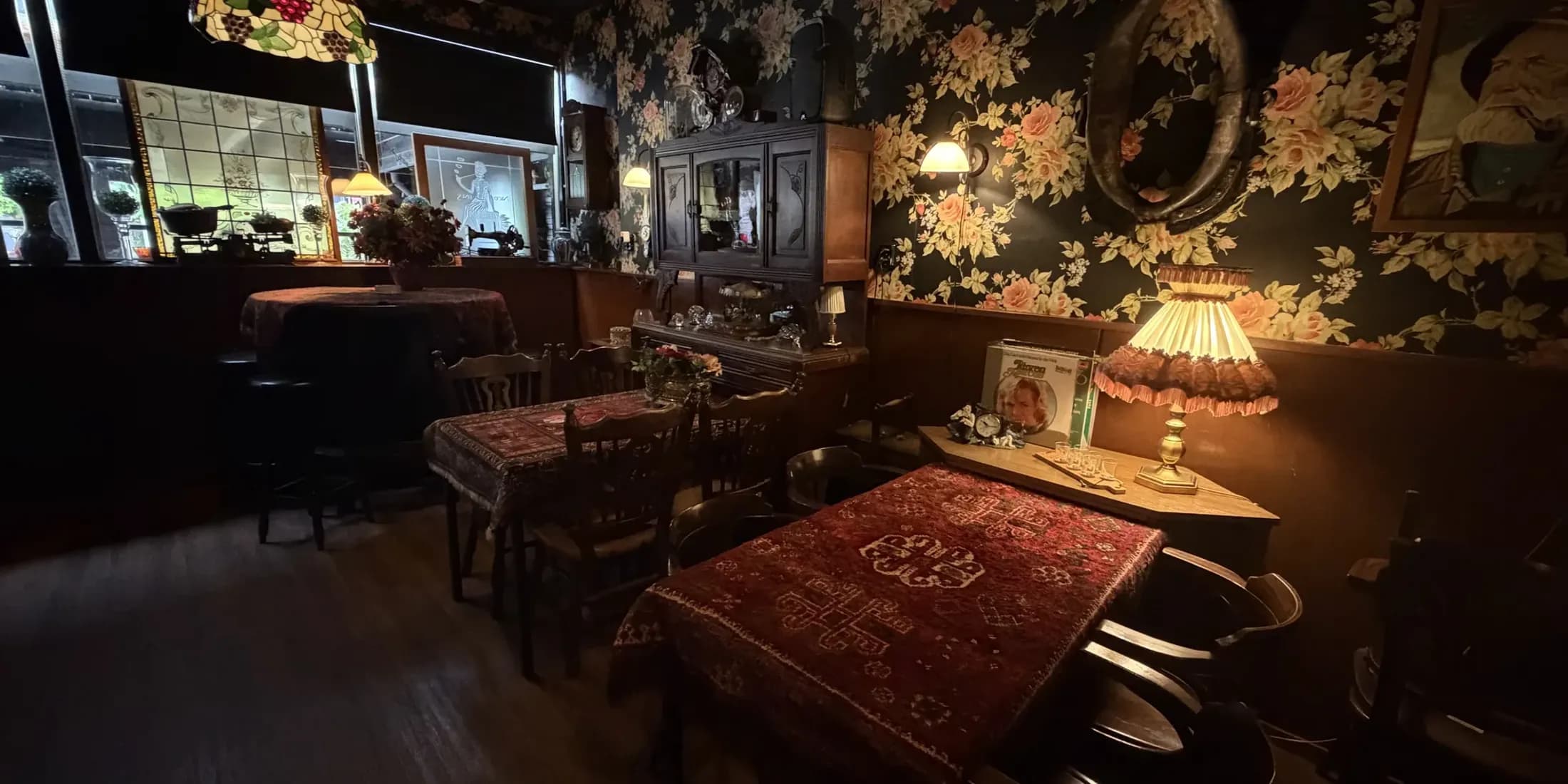 De stamtafel met Perzisch kleed en bloemenbehang