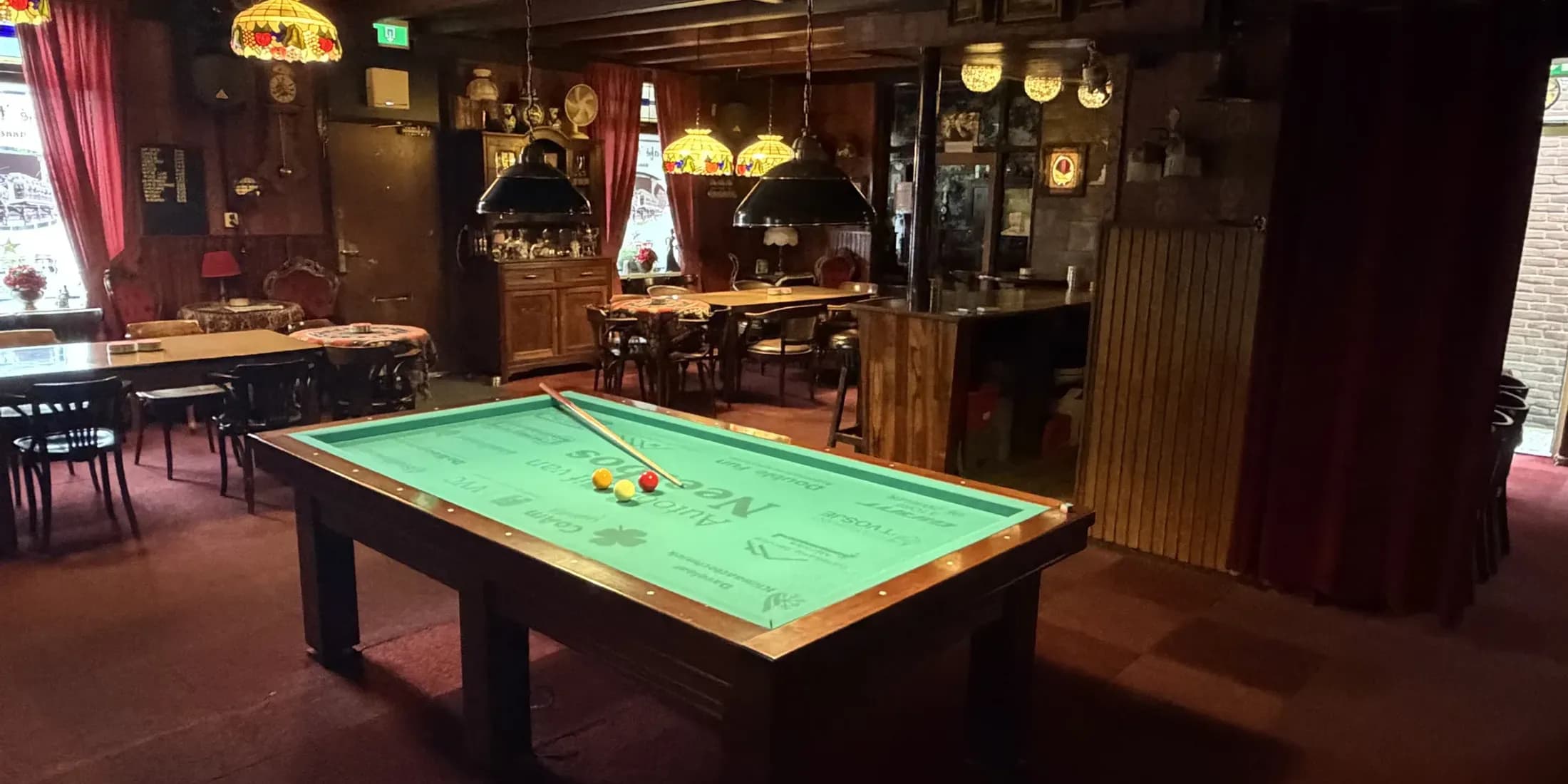 De biljartzaal met lampen boven de tafel